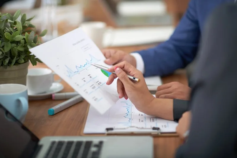 Hands reviewing analytics chart during an in-depth SEO audit meeting.