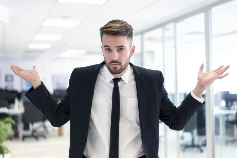 Frustrated businessman shrugs, confused why SEO results have dropped.