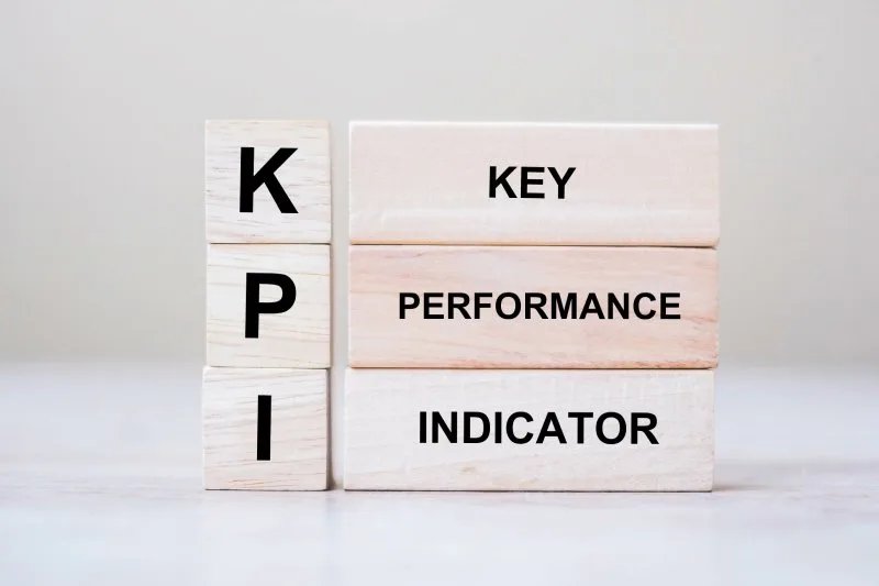 Wooden blocks display KPI acronym and key performance indicator definition for Google Analytics measurement clarity.