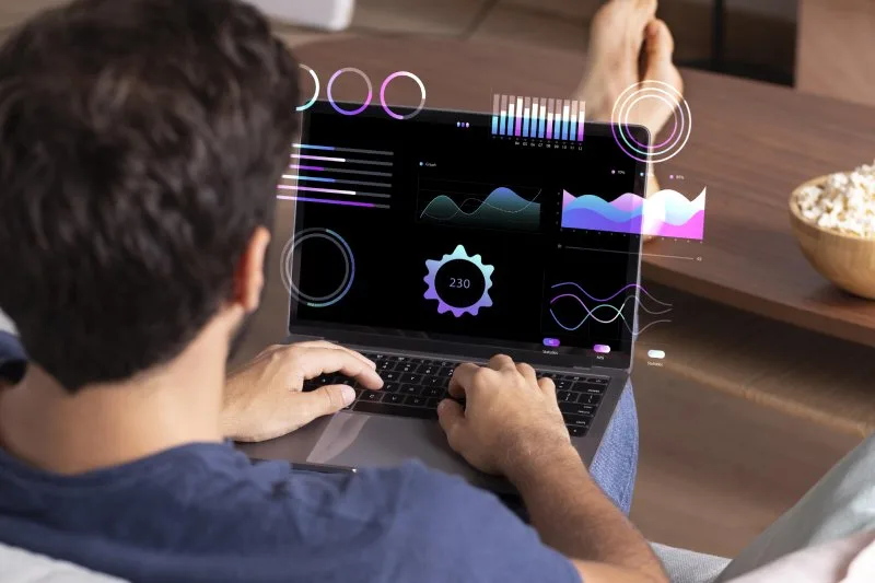 Man analyzing futuristic marketing data visualizations on his laptop screen.