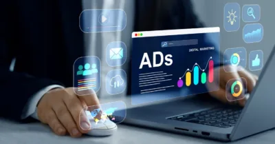 Digital marketer using laptop with advertising analytics icons, illustrating paid search vs paid social strategy differences.