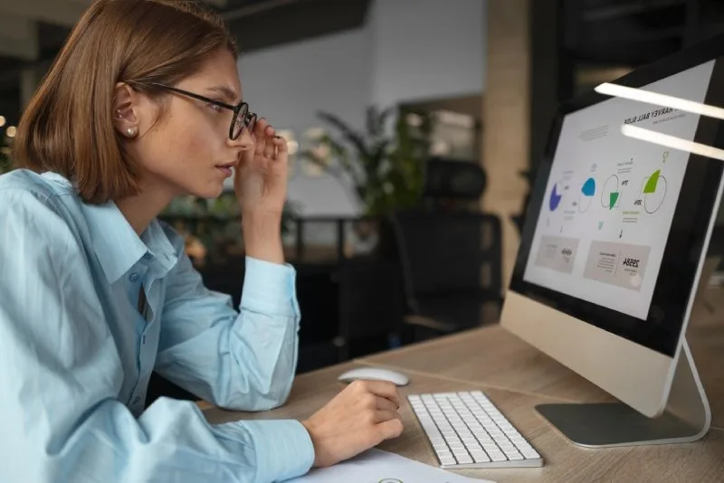 A woman stares at a computer looking at the impact of AEO on SEO