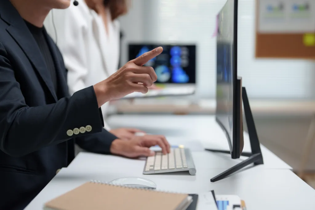 Professionals reviewing financial data on a computer in an office.