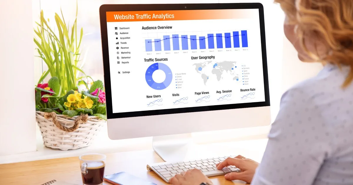 Analyst reviews website traffic analytics on desktop, monitoring audience overview, traffic sources, and user geography KPIs.