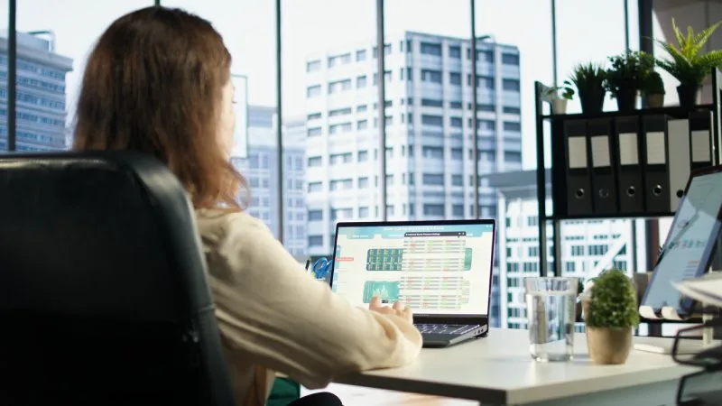 Real estate broker analyzing AI visibility dashboard on laptop, optimizing marketing KPIs and search performance.