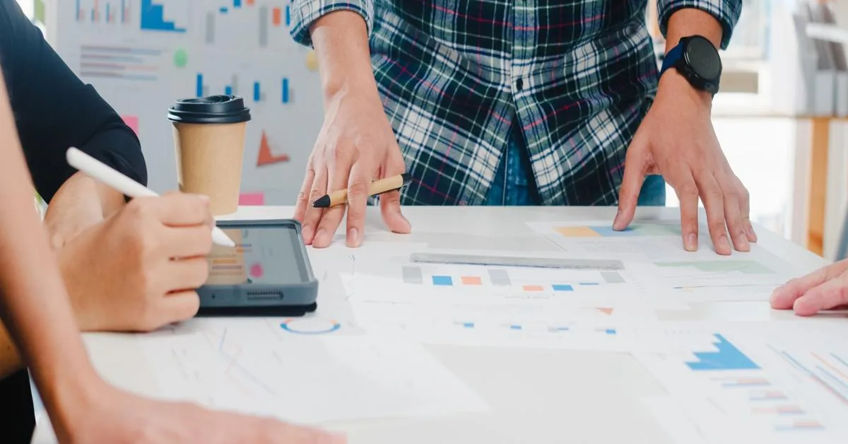 Questions for SEO agency team meeting with charts and tablet.
