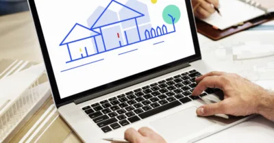 Laptop displaying house illustration while broker evaluates website branding for improved AI visibility in search.