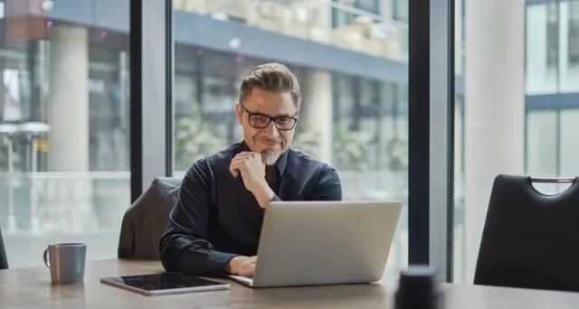 Financial services executive reviewing marketing performance data on a laptop