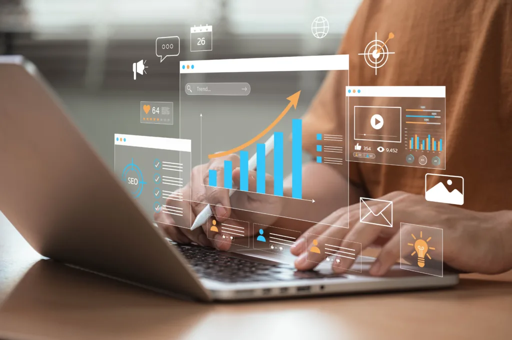 A person works on a laptop with digital overlays of marketing data, including growth charts, SEO metrics, social media icons, and video analytics.