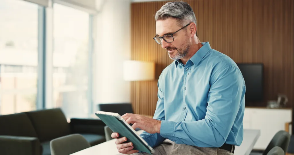 Financial advisor using a tablet in a modern office setting.