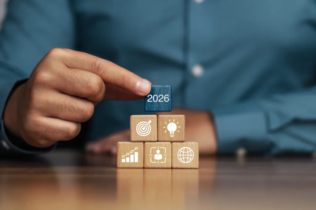 Hand placing a 2026 block above SEO strategy icons.