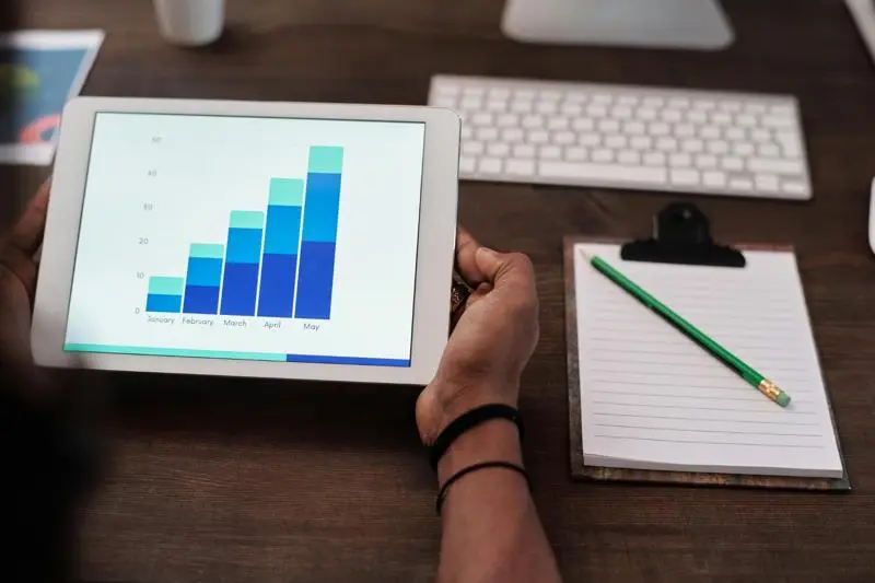 Tablet displaying SEO performance chart next to notepad and keyboard.