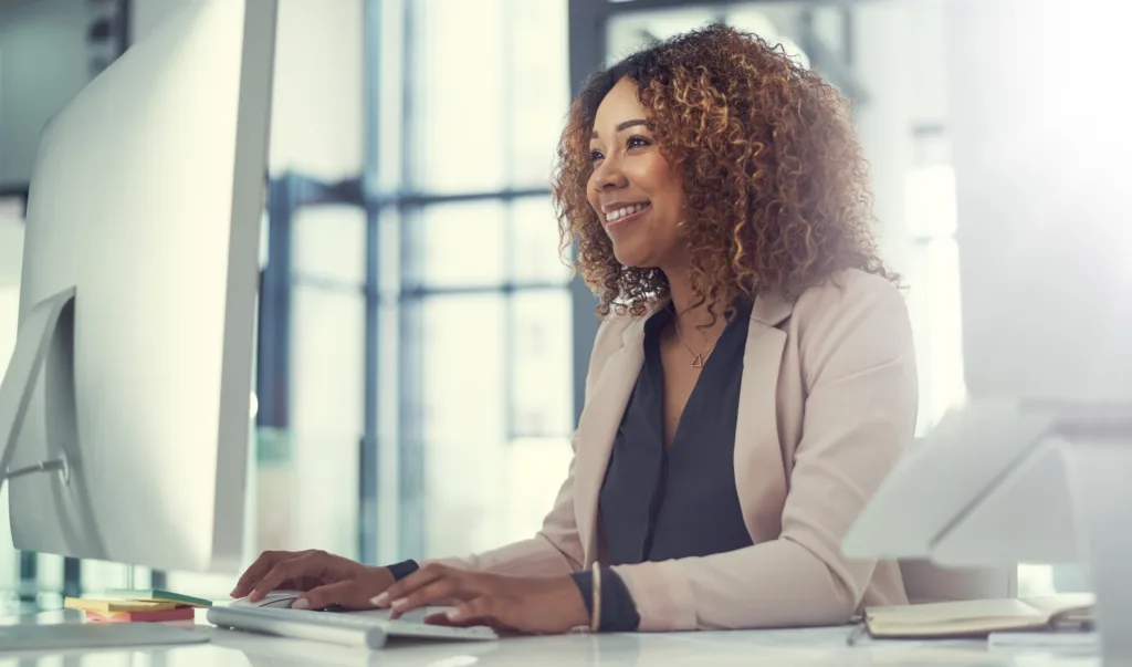 Financial professional using generative AI tools at her office computer.