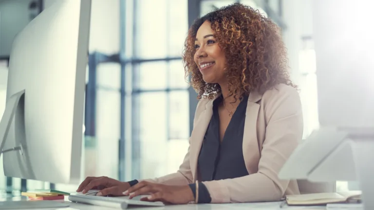 Financial professional using generative AI tools at her office computer.