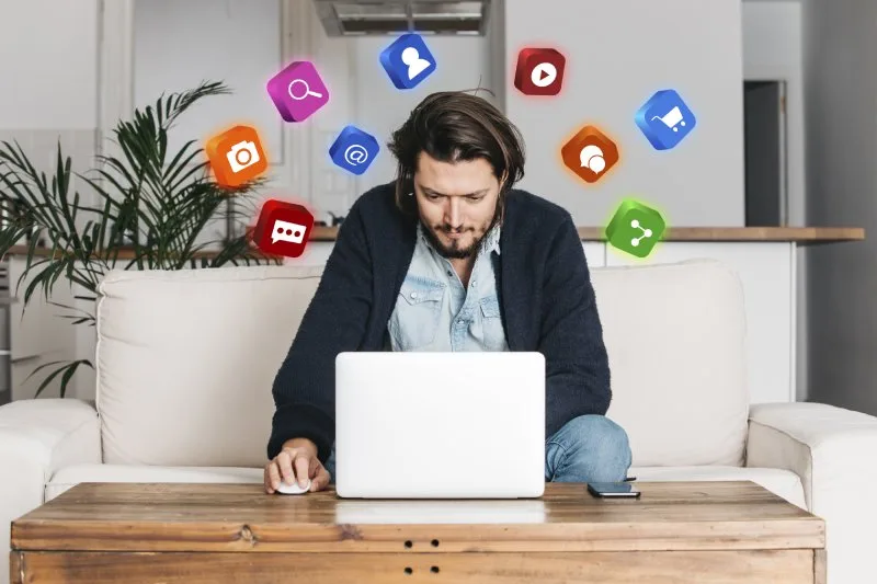 Top competitors social ads review, man on laptop with floating social media icons, brainstorming targets.