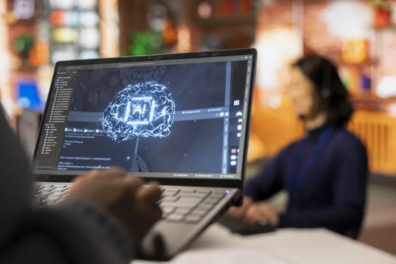 Laptop displaying an AI brain interface during a workplace technology review.