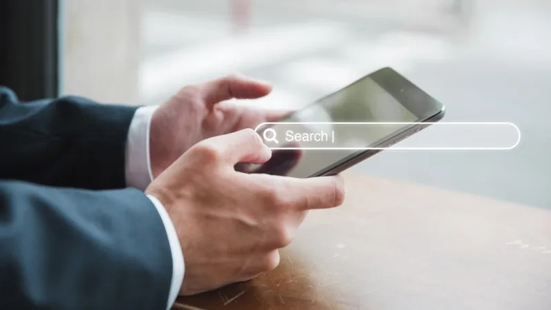 Close-up of a mobile device with a search bar, showing paid search intent-driven advertising.