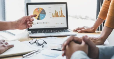 Marketing team reviewing analytics reports and data charts during a strategy meeting at the office.